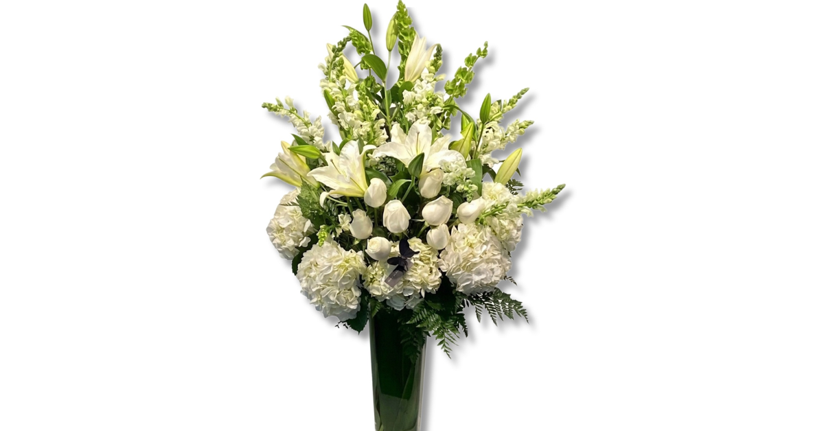 Elegant white sympathy flowers arrangement with lilies, tulips, and hydrangeas